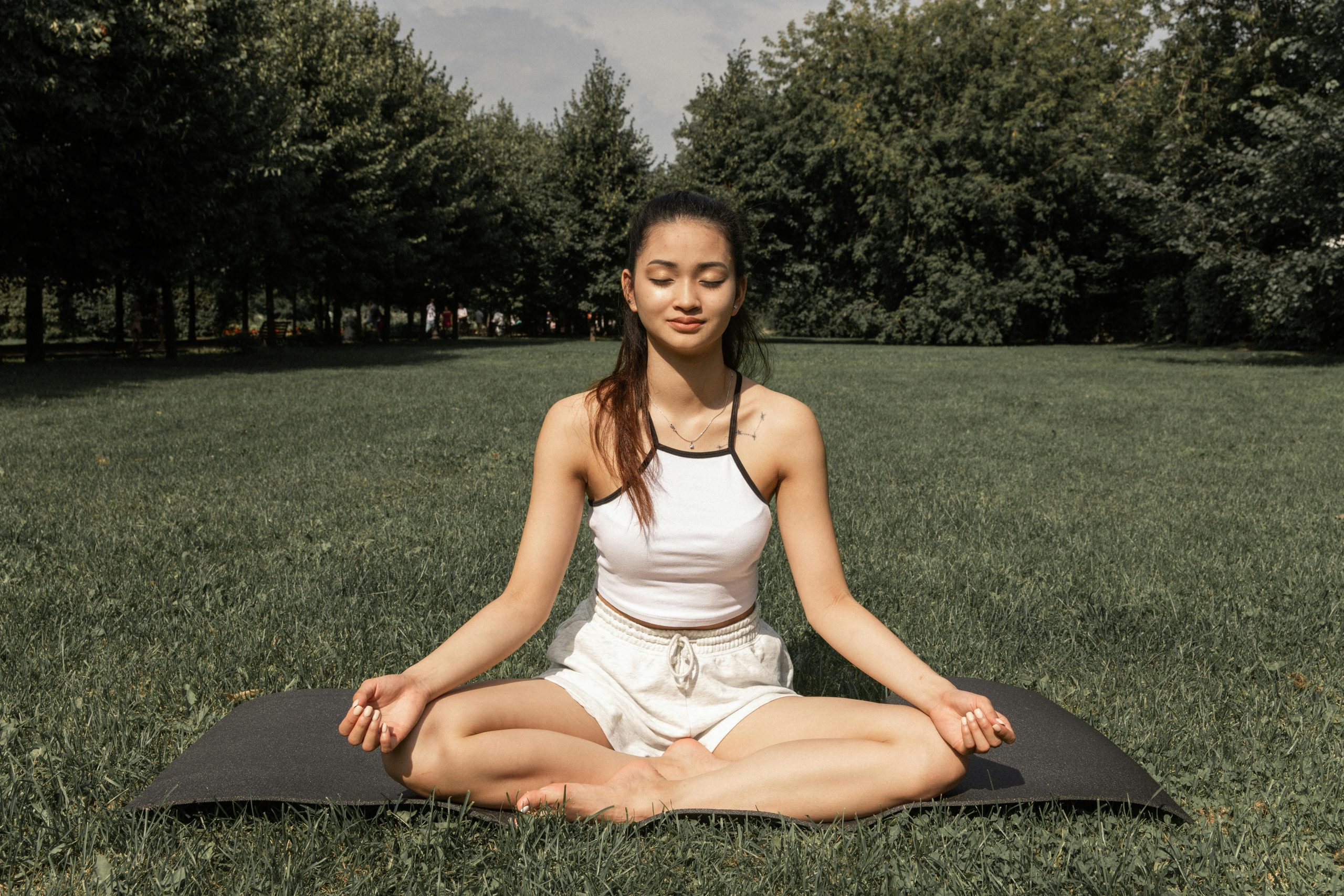 una  mujer con ropa de ejercicio meditando en el parque