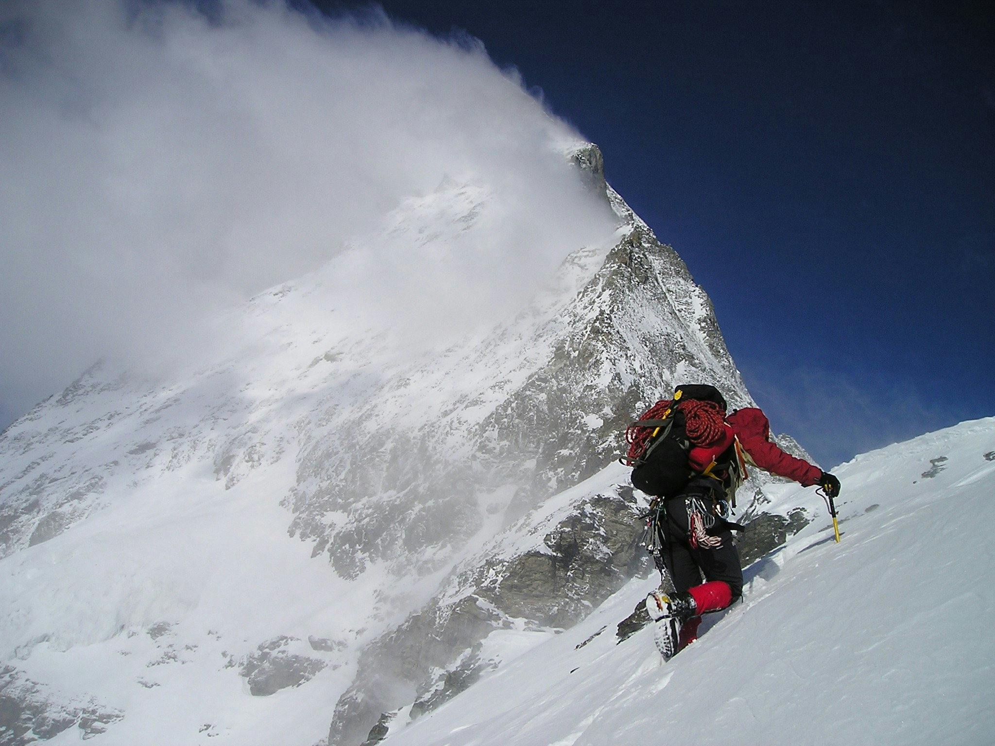 una persona tomando acción incluso con miedo escalando peligrosa montaña de nieve