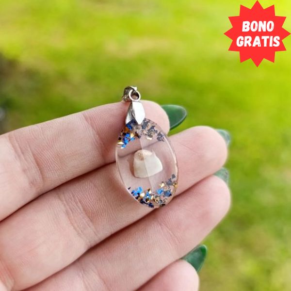 En la imagen se puede ver un pendiente realizado con resina epóxica sostenido en los dedos de una mano de mujer