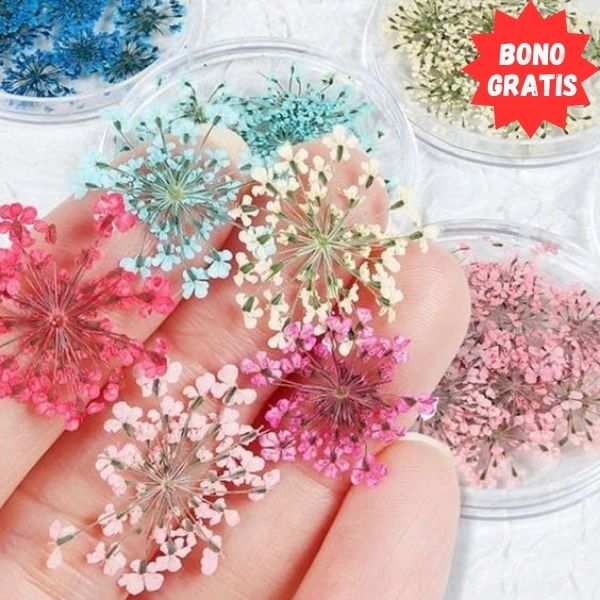 En la imagen se puede ver figuras como flores con distintos colores (celeste, rosado, azul, amarillo claro, blanco) hechas con resina epóxica 