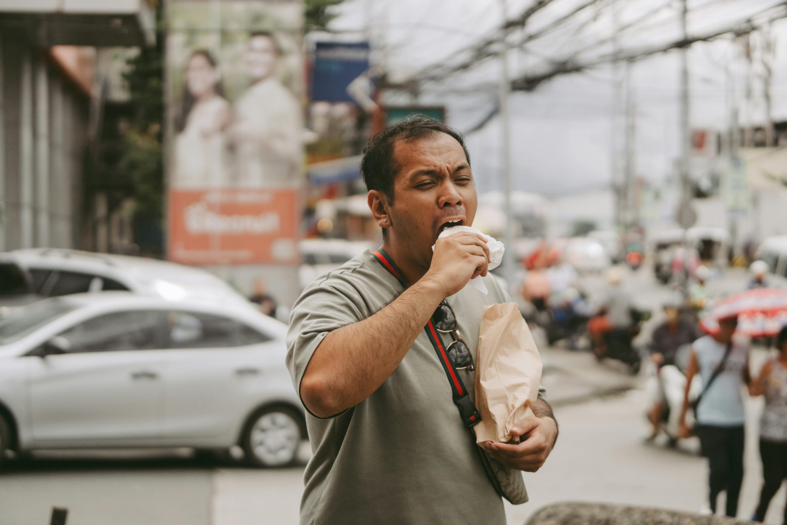 Persona comiendo comida poco saludable en la calle, representando el descuido de la alimentación diaria